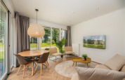 Modernes Wohnzimmer im Happy Oak Lodge im Holiday Park Mölke, Niederlande, mit großen Fenstern.