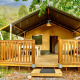 Tenda safari con terrazza in legno al Camping Delle Rose, circondata da alberi, Villatent Outback in Italia