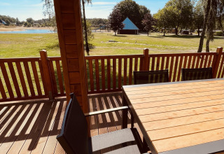 Vue depuis Lakehouse Scandi à Wilsumer Berge, Allemagne, avec terrasse en bois, table, chaises et nature autour.