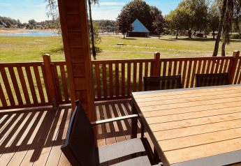 Blick von der Lakehouse Scandi Lodge in Wilsumer Berge, Deutschland, mit Holzterrasse und grüner Landschaft.