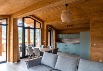 Modern houten interieur in Lakehouse Scandi, Wilsumer Berge, Duitsland, met keuken en eetplaats.