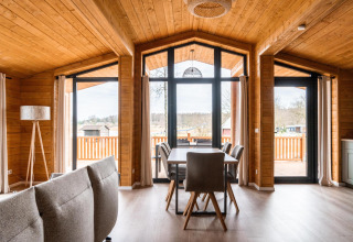 Interiør af Lakehouse Scandi-lodge ved Wilsumer Berge i Tyskland med moderne trædesign og store vinduer.
