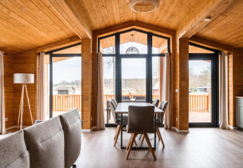 Interiør af Lakehouse Scandi-lodge ved Wilsumer Berge i Tyskland med moderne trædesign og store vinduer.