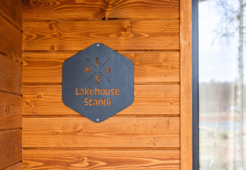 Metalen bord aan houten muur bij Lakehouse Scandi lodge in Wilsumer Berge, Duitsland, Scandinavische stijl.
