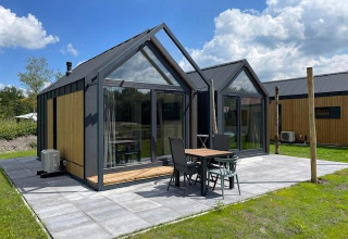 Pequeña casa moderna Cosy house en Camping Si-Es-An, Países Bajos, con terraza y grandes ventanales.