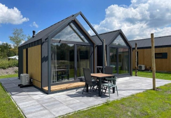 Lille, moderne Cosy house ved Camping Si-Es-An i Holland, med store vinduer og terrasse i solskin.