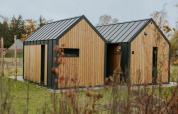 Acogedora tiny house llamada Cosy house en Camping Si-Es-An, Países Bajos, rodeada de naturaleza verde.