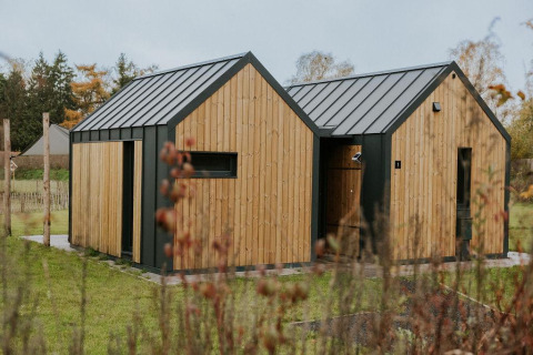 Gezellig tiny house genaamd Cosy house bij Camping Si-Es-An in Nederland, met houten buitenkant.