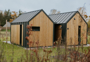 Acogedora tiny house llamada Cosy house en Camping Si-Es-An, Países Bajos, rodeada de naturaleza verde.