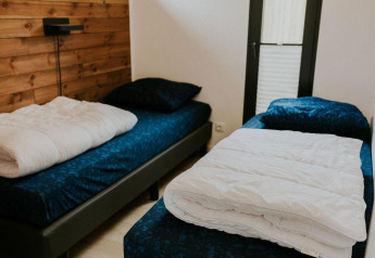 Schlafzimmer mit zwei Einzelbetten im Cosy House auf Camping Si-Es-An, Niederlande, gemütliche Atmosphäre.