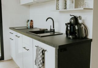 Moderna cocina pequeña en una tiny house acogedora en Camping Si-Es-An, Países Bajos, con decoración minimalista
