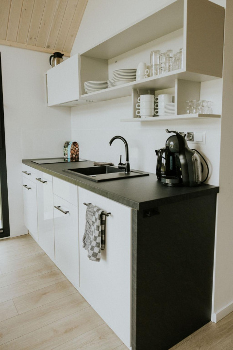 Petite cuisine moderne d'une tiny house cosy au Camping Si-Es-An aux Pays-Bas, décor noir et blanc élégant