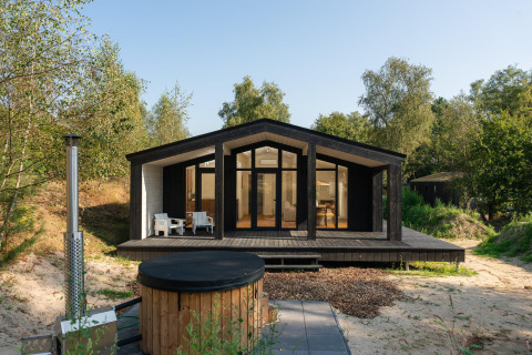 Tiny house moderne avec terrasse en bois et bain nordique extérieur à Wilsumer Berge, Allemagne, en pleine nature.