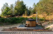 Bañera de hidromasaje de madera al aire libre junto a una tiny house en Wilsumer Berge, Alemania.