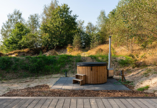Bañera de hidromasaje de madera al aire libre junto a una tiny house en Wilsumer Berge, Alemania.