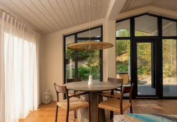 Lyst og moderne spiseområde i et tiny house med udsigt over naturen ved Wilsumer Berge, Tyskland.