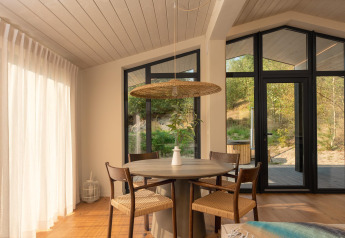 Lichte, moderne eethoek in een tiny house met uitzicht op de natuur bij Wilsumer Berge, Duitsland.