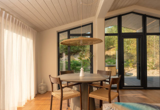 Lyst og moderne spiseområde i et tiny house med udsigt over naturen ved Wilsumer Berge, Tyskland.