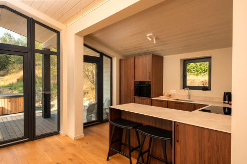 Petite cuisine moderne avec éléments bois, grandes fenêtres et vue nature à Hills avec Hot tub, Wilsumer Berge.