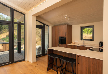 Moderne tiny house keuken met houtaccenten, grote ramen en natuurzicht bij Hills met Hot tub, Wilsumer Berge.