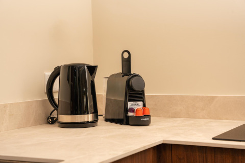 Kitchen corner with a black kettle and capsule coffee maker in a tiny house at Wilsumer Berge, Germany.
