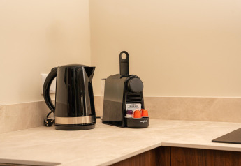 Kitchen corner with a black kettle and capsule coffee maker in a tiny house at Wilsumer Berge, Germany.
