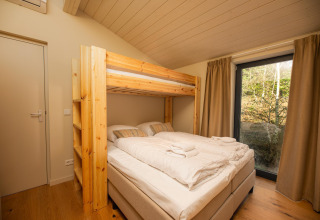 Camera luminosa con letto a castello nella tiny house Hills con vasca idromassaggio a Wilsumer Berge, Germania.