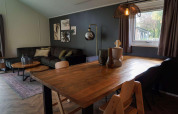 Kinderfreundliche Lodge in Kaatsheuvel, Niederlande, mit gemütlichem Wohnbereich und Holztisch.