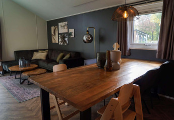 Kinderfreundliche Lodge in Kaatsheuvel, Niederlande, mit gemütlichem Wohnbereich und Holztisch.