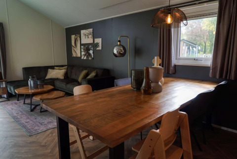 Kindvriendelijke lodge in Kaatsheuvel, Nederland, met warme inrichting en grote houten tafel.