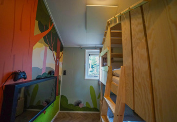 Kinderzimmer im Kids Cottage, Kaatsheuvel, Niederlande mit Etagenbett, Wandbild und Spielkonsole.