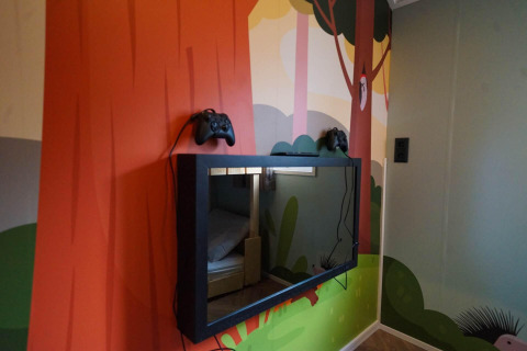 Fresque murale avec télévision et deux manettes de jeu au Kids Cottage, Kaatsheuvel, Pays-Bas, ambiance enfant.
