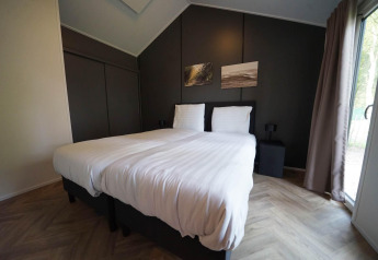 Dormitorio moderno en Kids Cottage, Kaatsheuvel, Países Bajos, con una cama doble y paredes oscuras.