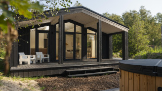 Tiny house moderna The Hills con ampia terrazza in legno, vasca idromassaggio e sauna tra il verde.