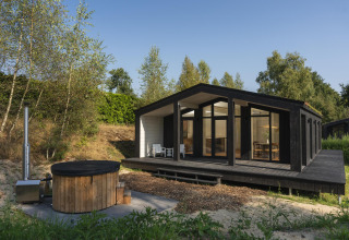 Casa tiny moderna 'The Hills' con grandes ventanales, jacuzzi y sauna en Wilsumer Berge, Alemania.