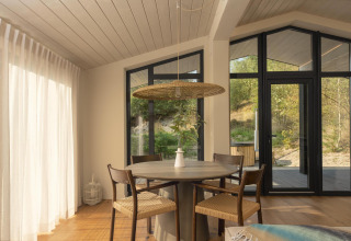 Luminoso comedor moderno en la tiny house The Hills con vistas a la naturaleza en Wilsumer Berge, Alemania.