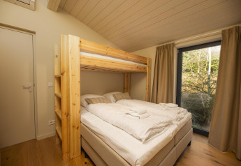 Soveværelse i en tiny house på The Hills med køjeseng, dobbeltseng, vindue og naturudsigt, Wilsumer Berge.