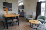 Woon- en eetgedeelte van Dune Lodge bij EuroParcs Parc du Soleil in Nederland, met modern interieur en licht.