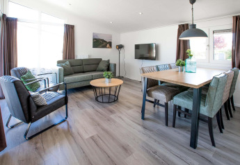 Moderne woon- en eetkamer in Dune Lodge bij EuroParcs Parc du Soleil, Nederland, met stijlvol interieur.