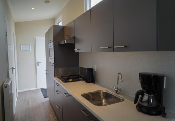 Moderne keuken in Dune Lodge bij EuroParcs Parc du Soleil in Nederland met koffiezetapparaat en gasfornuis.