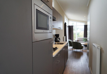 Angolo cottura moderno in una Dune Lodge a EuroParcs Parc du Soleil con vista su soggiorno luminoso.