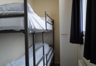 Køjeseng med hvidt sengetøj i et lille værelse på Dune Lodge, EuroParcs Parc du Soleil, Holland.