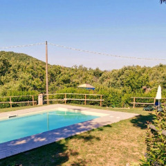 Outdoor swimming pool overlooking hills and greenery at Camping Lucherino holiday park in Tuscany, Italy.