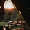 Sunset over the countryside as seen from a cozy outdoor dining area at Feather Down Rochefort-Ardenne, Belgium.