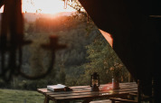 Sonnenuntergang über der Natur, gesehen von einem gemütlichen Esstisch im Feather Down Rochefort-Ardenne, Belgien.