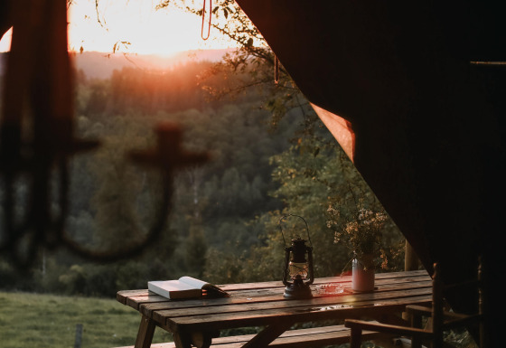 Atardecer en la naturaleza visto desde un acogedor comedor al aire libre en Feather Down Rochefort-Ardenne, Bélgica.