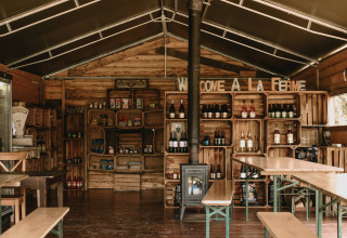 Interno accogliente in legno con scaffali di prodotti locali e bevande a Feather Down Rochefort-Ardenne.