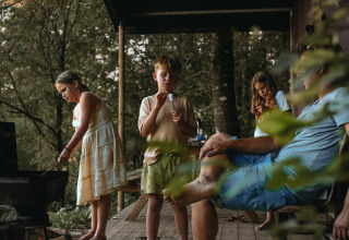 Familie entspannt auf einer Veranda im Wald im Feather Down Rochefort-Ardenne, Belgien Luxemburg.