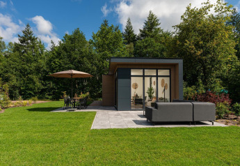Lodge moderne avec grandes fenêtres, terrasse et mobilier de jardin au Veluwepark de Bosgraaf, Pays-Bas.