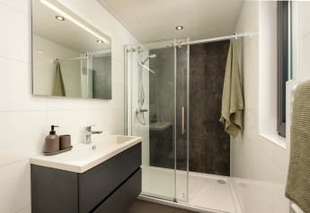 Bagno moderno con doccia e grande specchio a Cannenburch, Veluwepark de Bosgraaf, Paesi Bassi.
